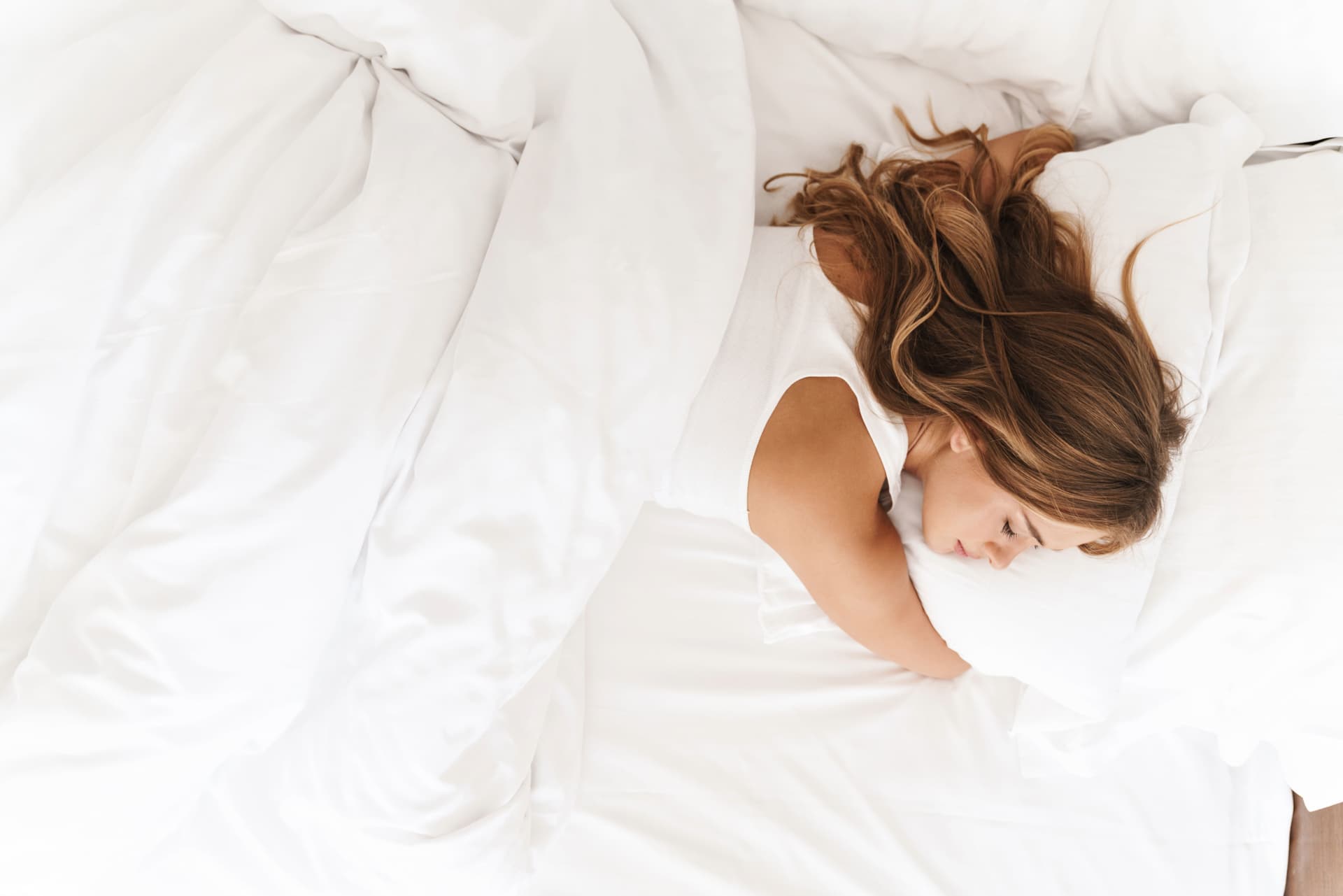 young woman sleeping in white